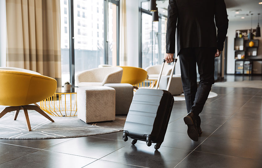 man pulling luggage at hotel